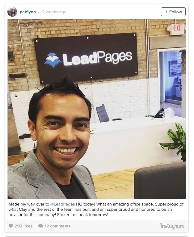 Pat at LeadPages headquarters, a brick walled lobby with a big blue and white LeadPages logo on the wall