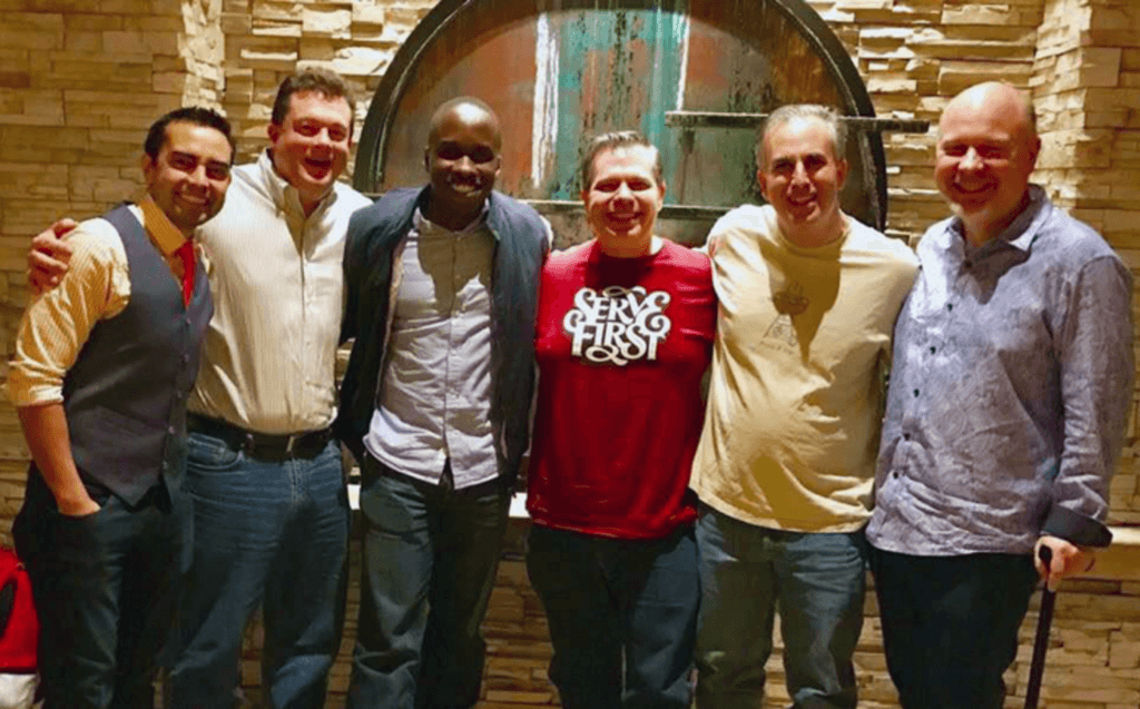 A group of six guys smiling for the camera