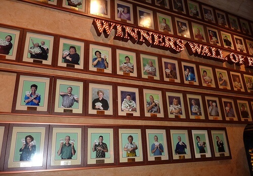 Wall of framed photos of winners