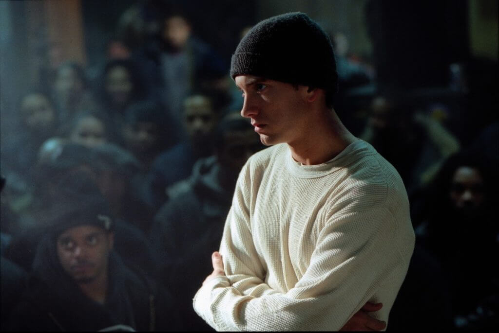 An image from the movie 8 Mile of Eminem in the middle of a rap battle, looking serious