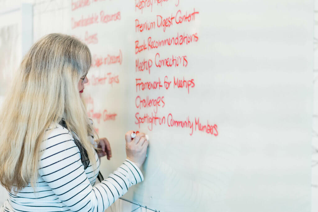 Mindy writing lots of ideas down on to a big whiteboard