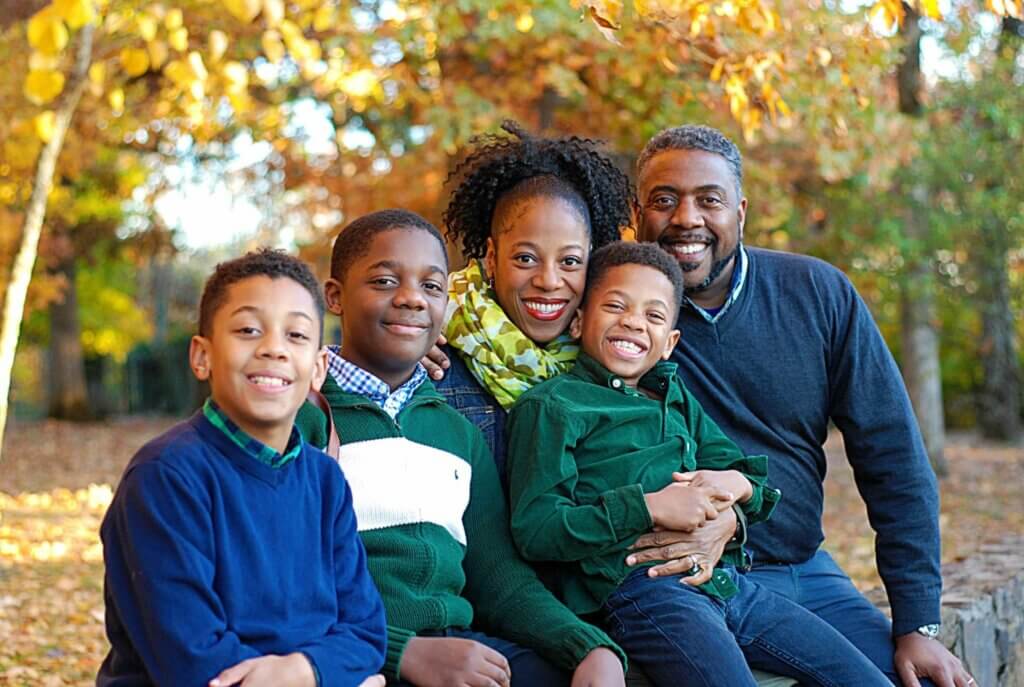 Randy Wilburn posing with wife and three boys outside in the autumn