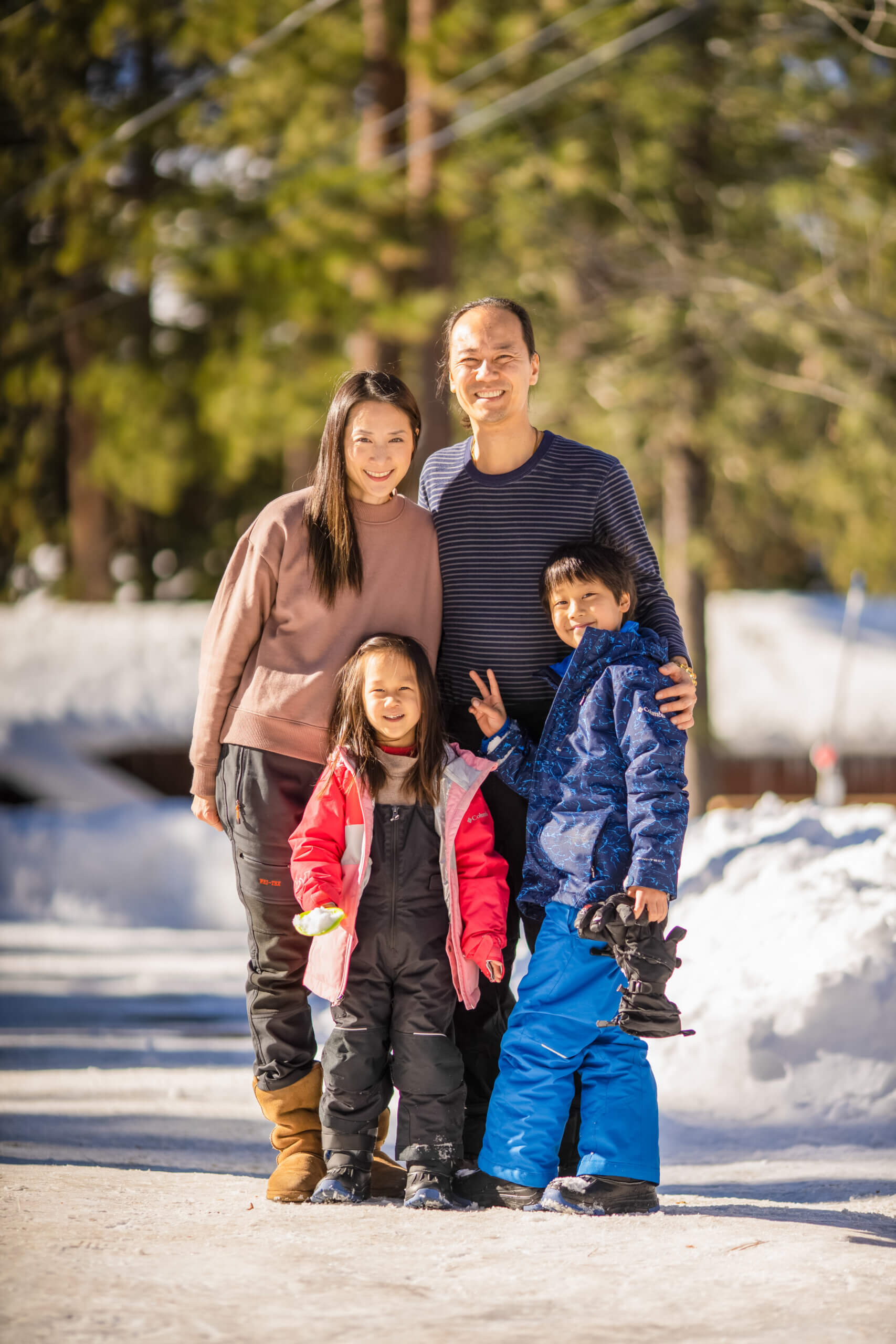 Benjamin Yeh standing outside in the snow with his family: wife and two children