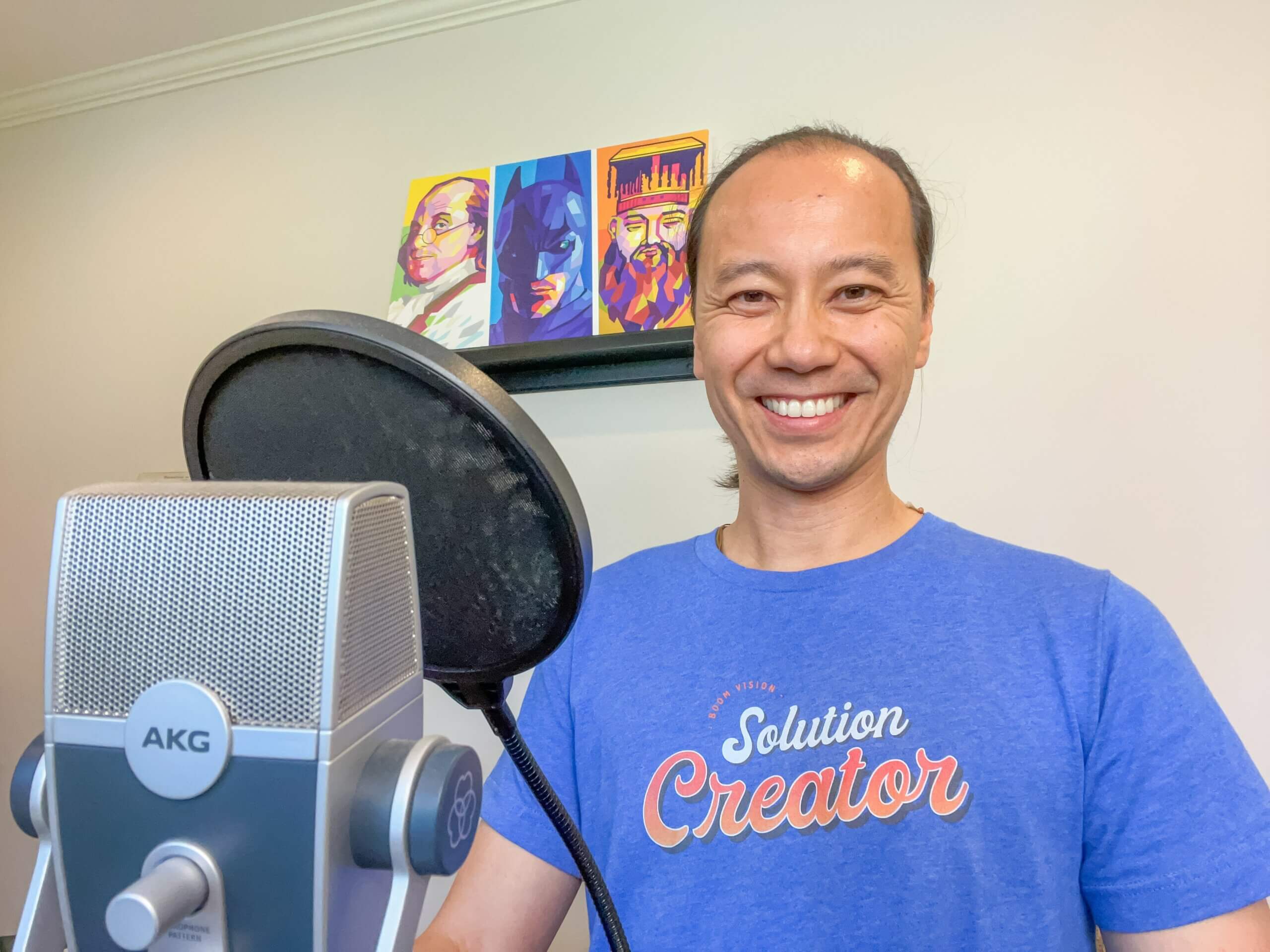 Benjamin Yeh at desk in front of a podcast microphone and pop filter