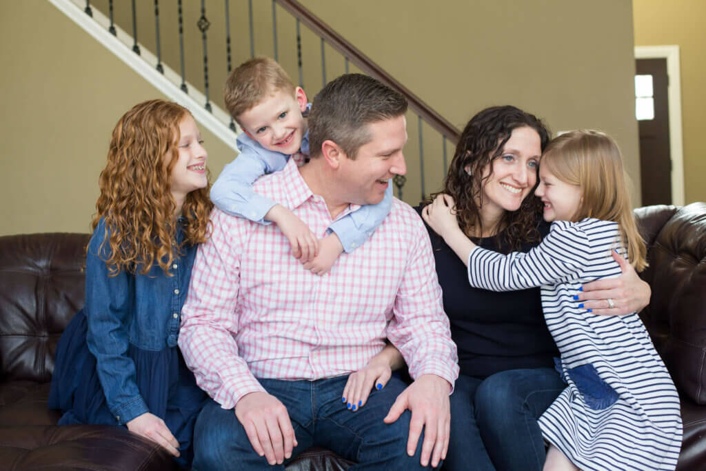 Rose Griffin sitting with her family on the couch (her husband, two daughters, and son)