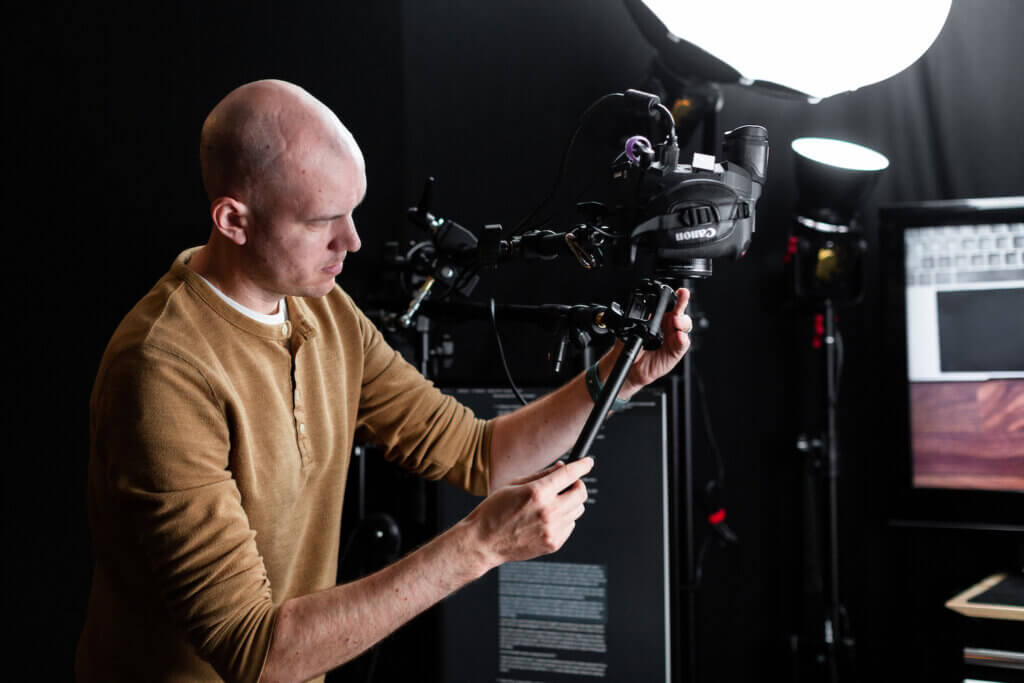 SPI Expert in Residence Caleb Wojcik makes an adjustment to a camera mount in studio.