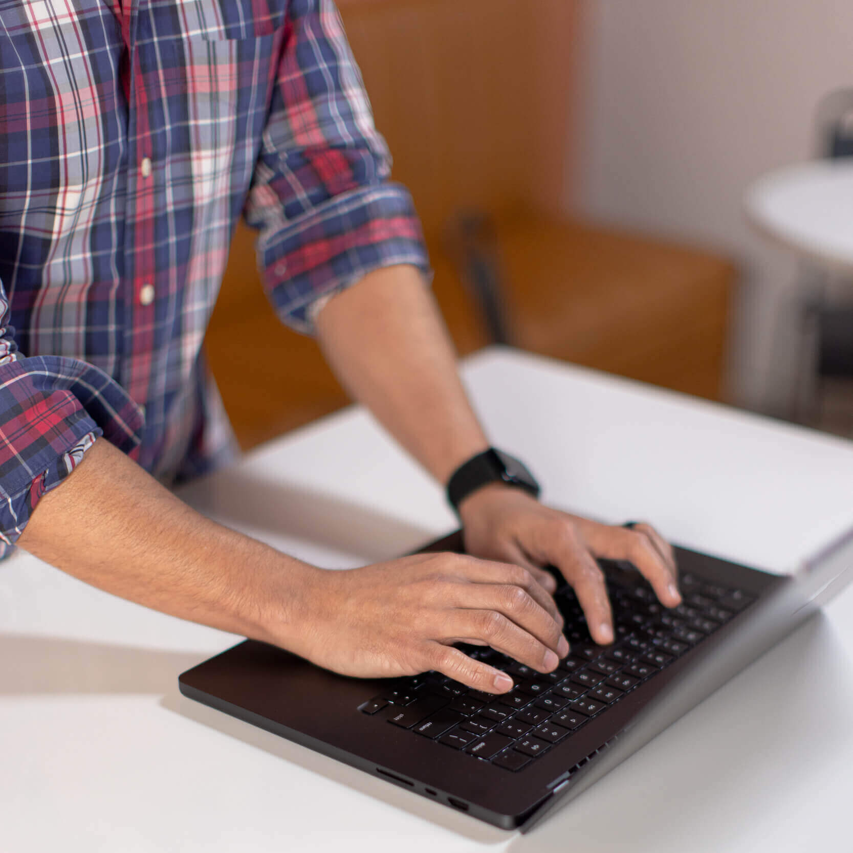Hands typing on a laptop